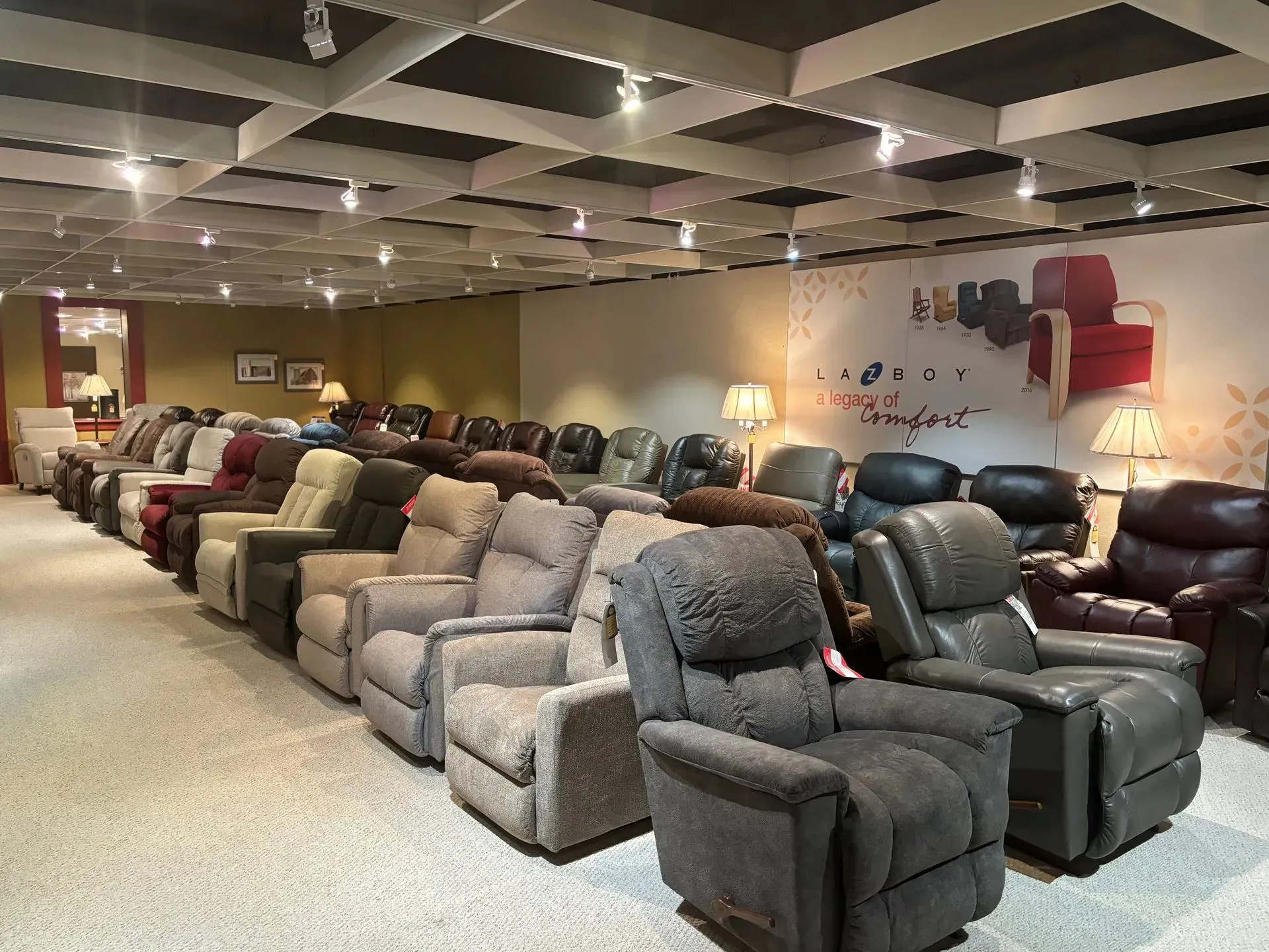 Row of recliners in a furniture showroom, various colors.