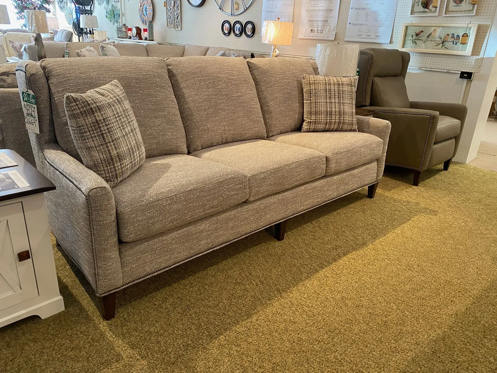 Beige textured couch with matching pillows in a furniture store.