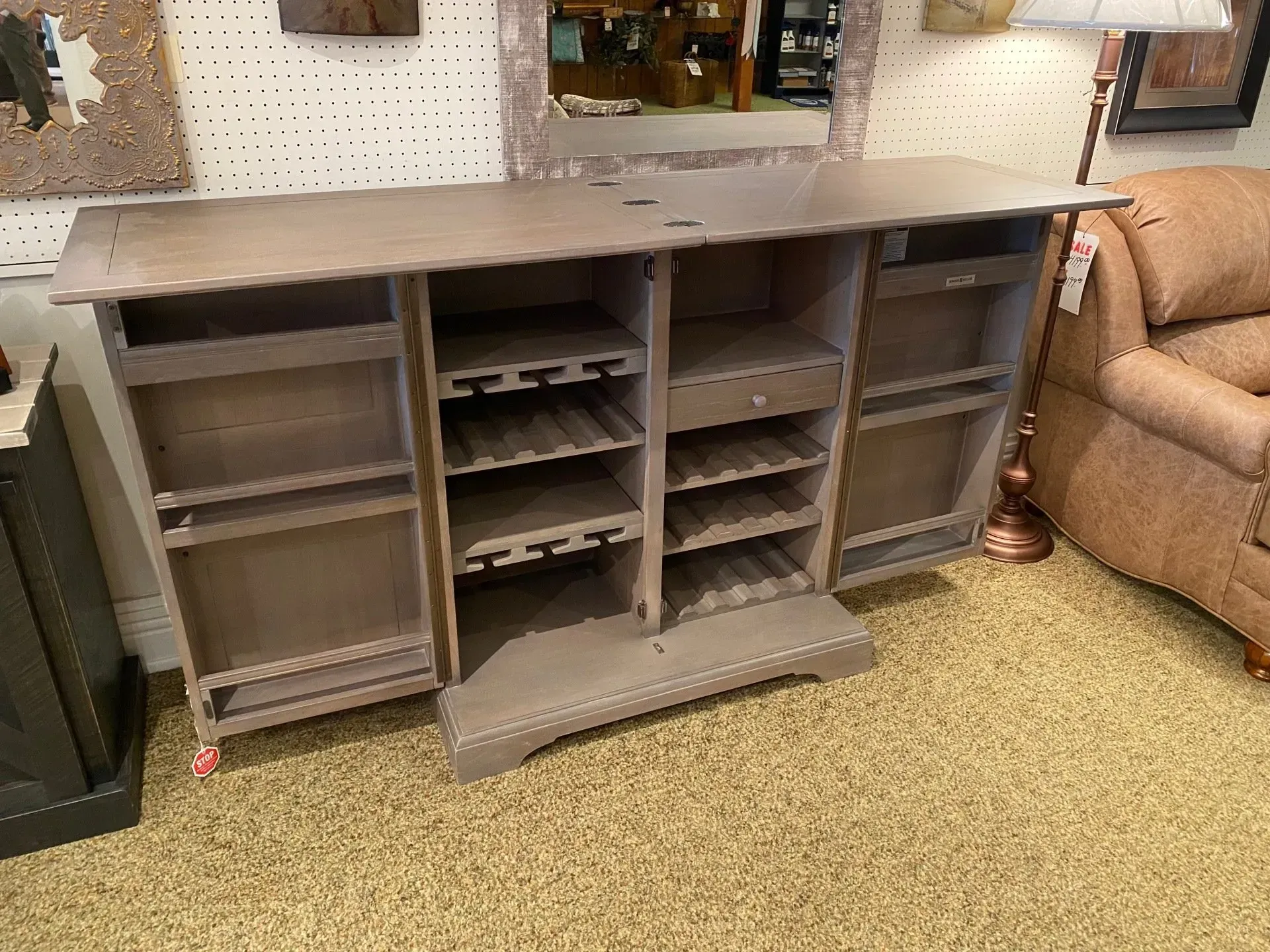 A wooden bar cabinet with open doors, shelves, and a wine rack. Beige and brown colors.