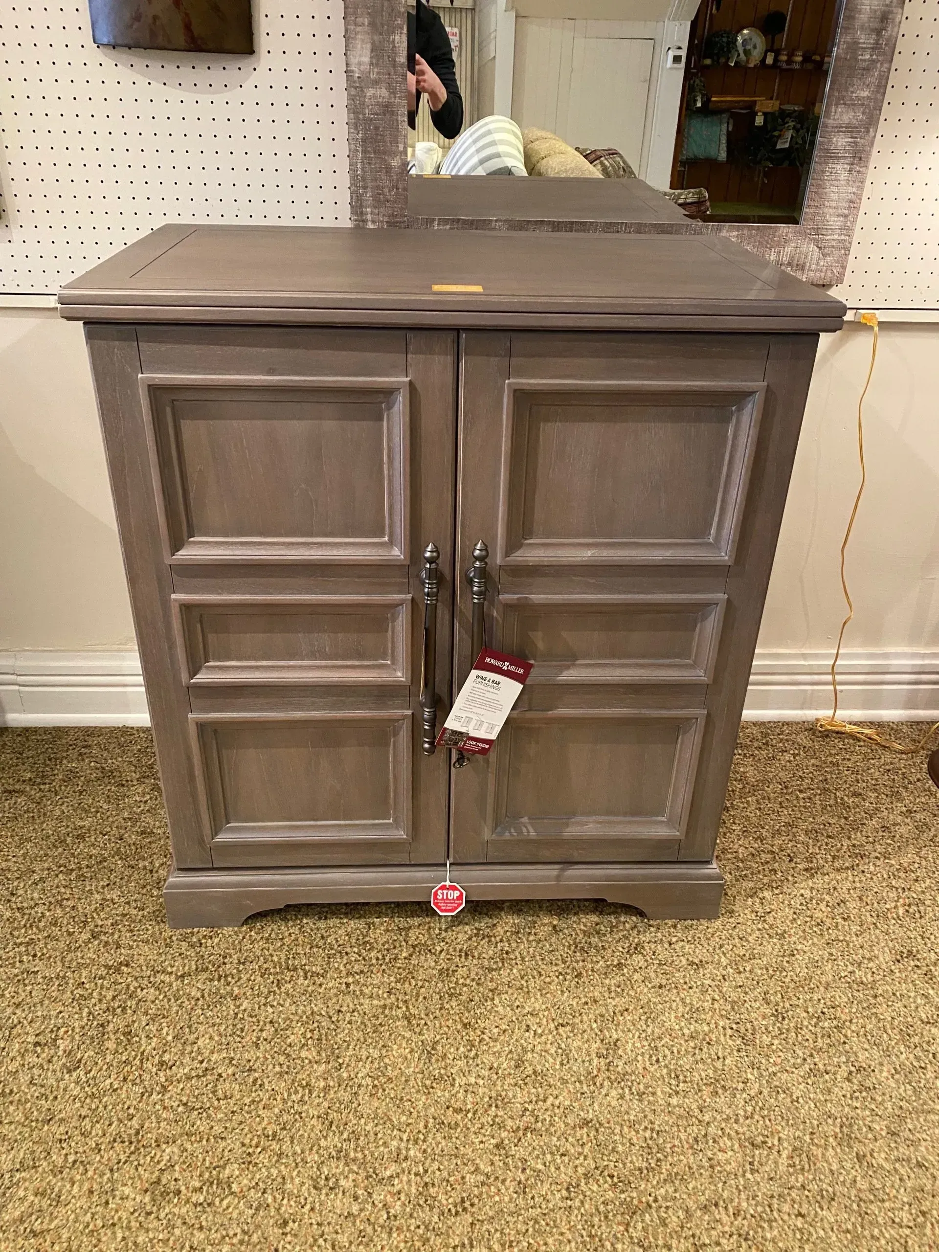 Gray wooden cabinet with two doors, handles, and a price tag.