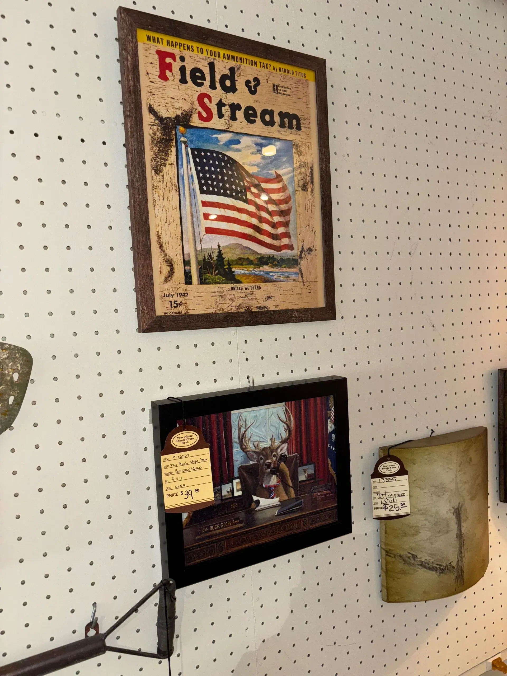 Field & Stream magazine cover art and deer scene art on a pegboard wall.
