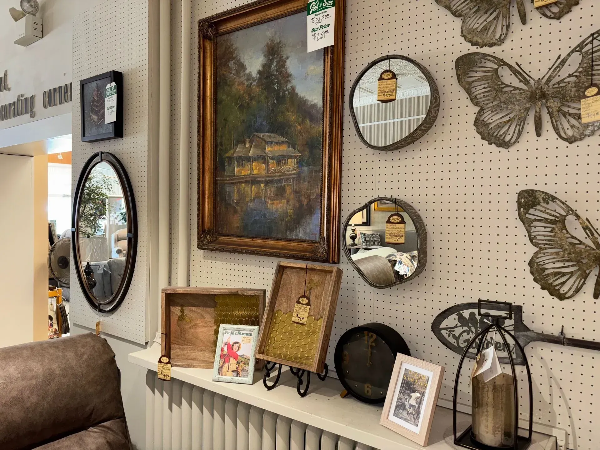Antique store display with artwork, mirrors, and decorative items.