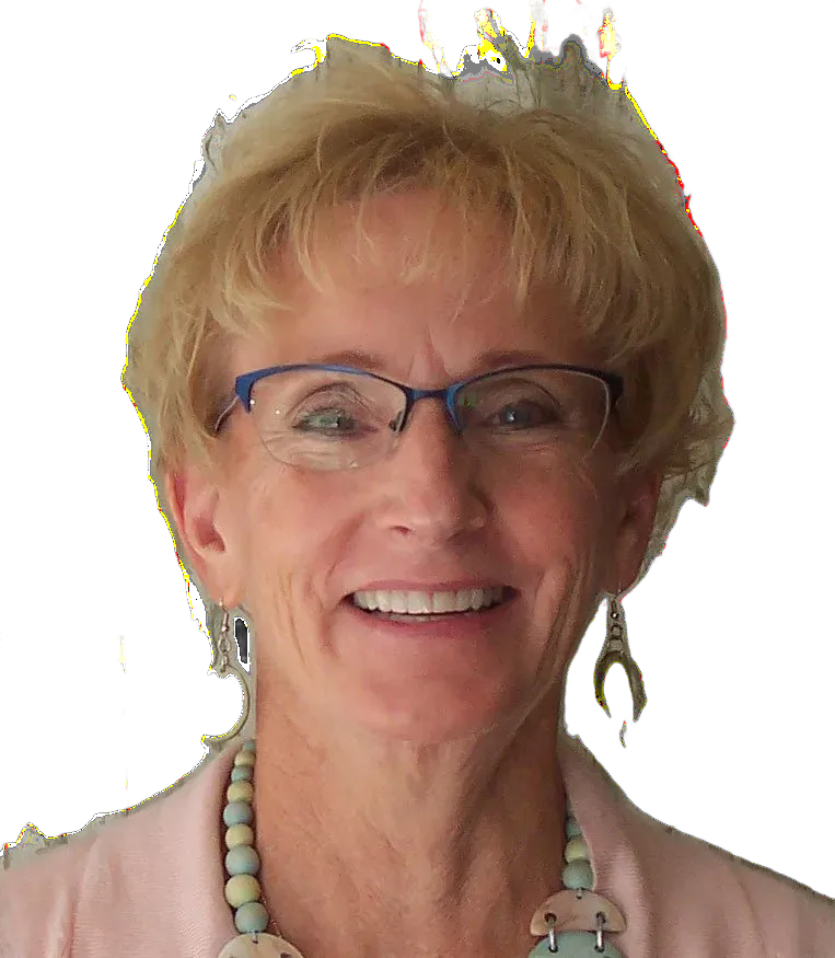Woman with glasses smiles, wearing pink top and beaded jewelry, against a patterned background.