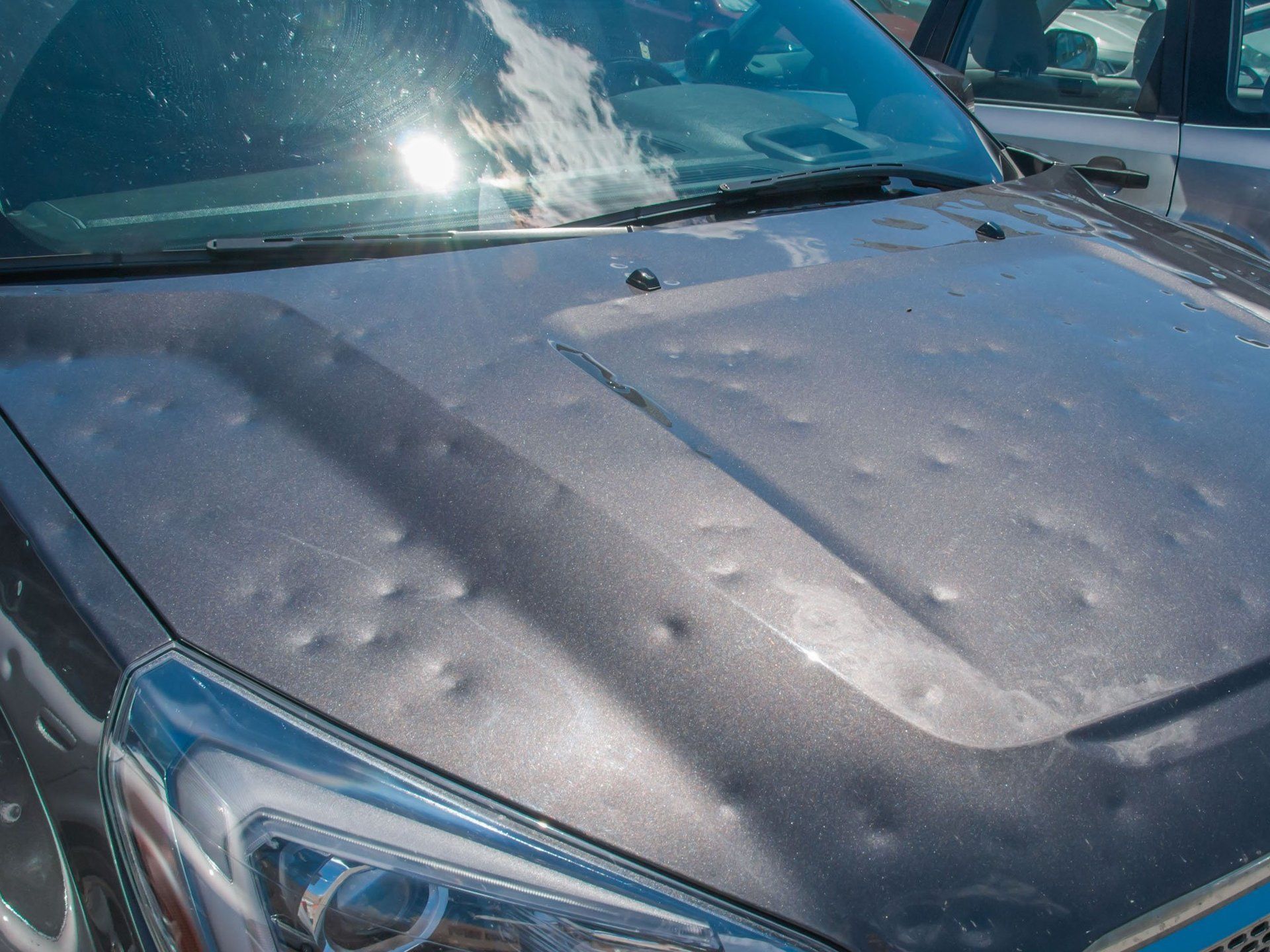 the hood of a car is covered in hail .