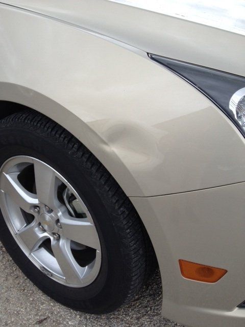 a close up of a car with a damaged fender