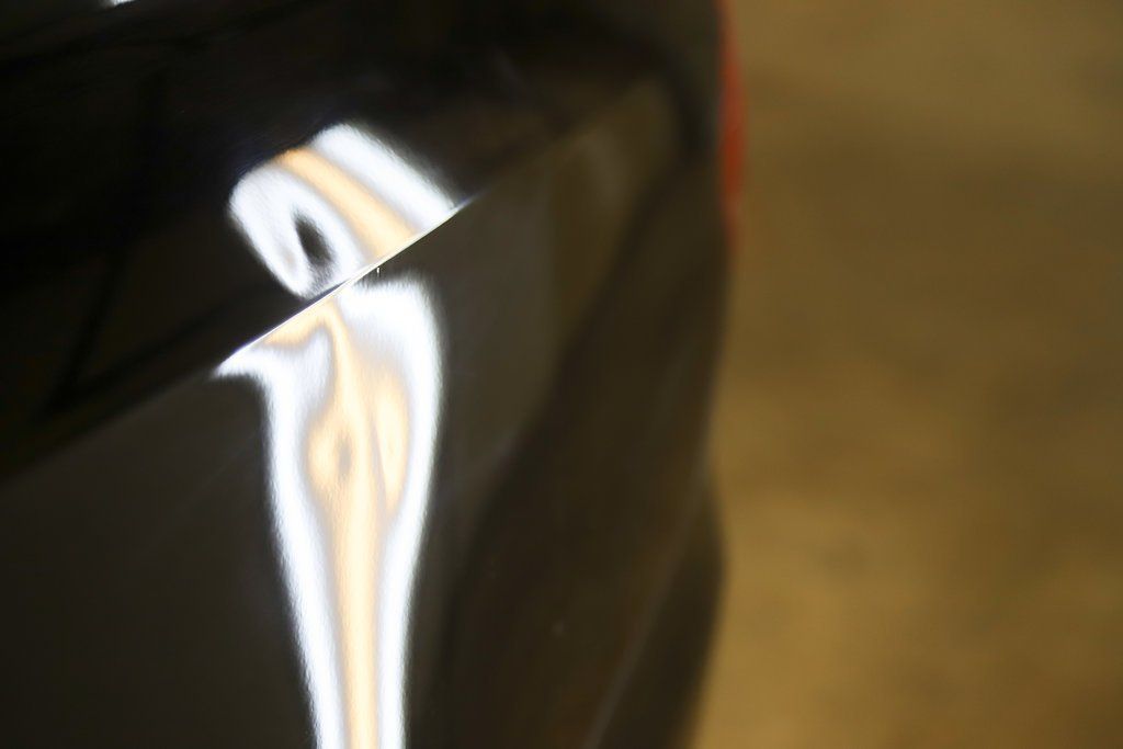 a close up of a car door with a dent in it .