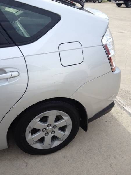 a silver car with a black tire is parked in a parking lot