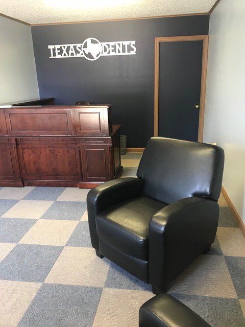 a chair in front of a texas dents sign