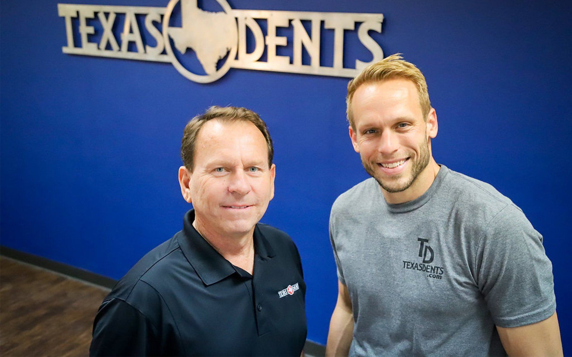 two men are standing in front of a sign that says texas dents