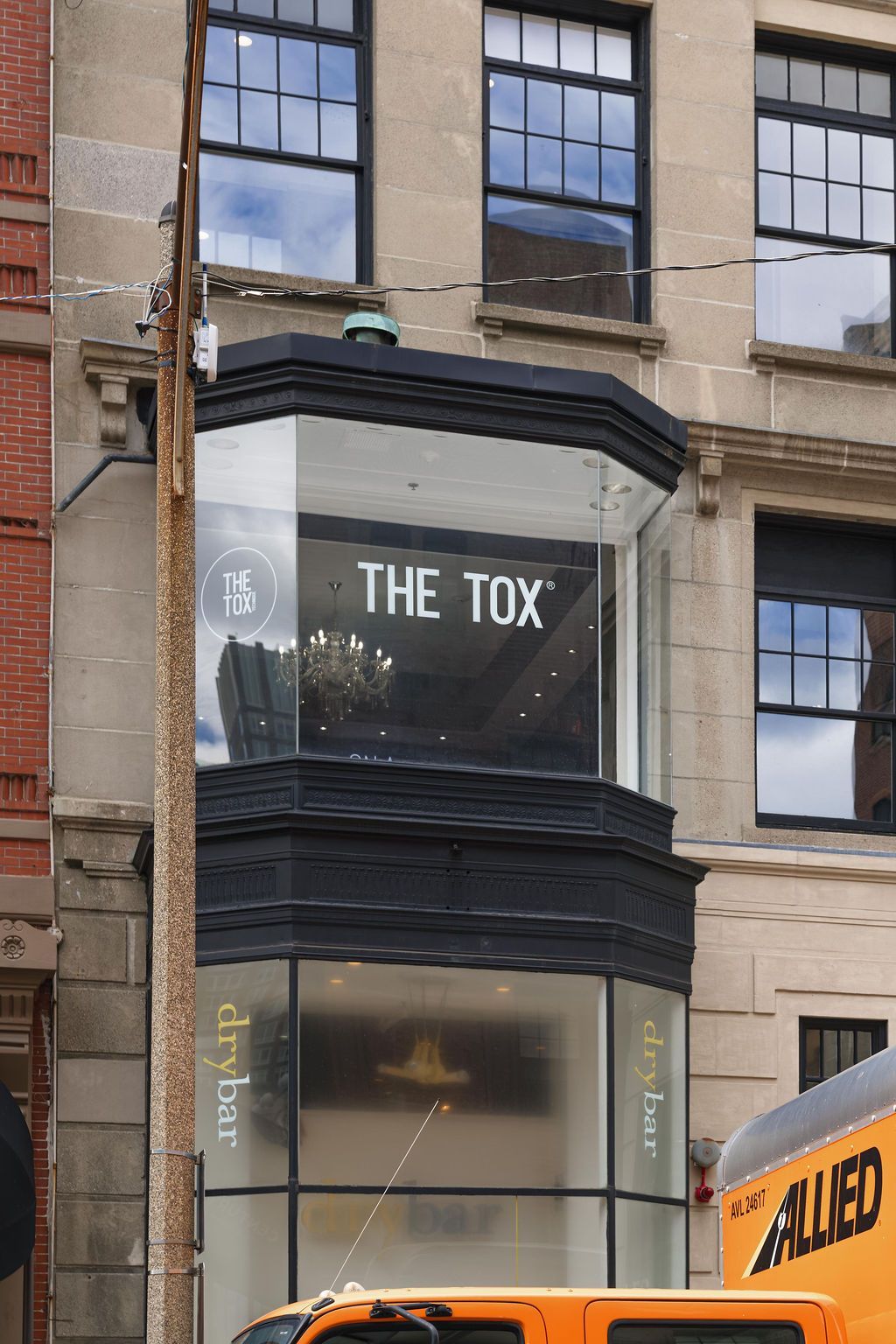 Storefront sign reading 'THE TOX' on a beige building with dark trim.