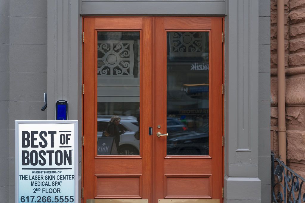 Orange double doors beside a 'Best of Boston' sign on a gray building exterior
