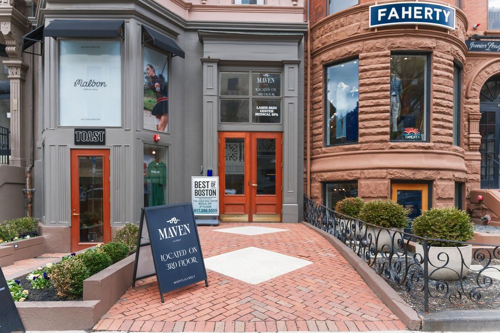 Storefront with brick facade, glass windows, orange door, and a blue 'FAHERTY' sign above the entrance.