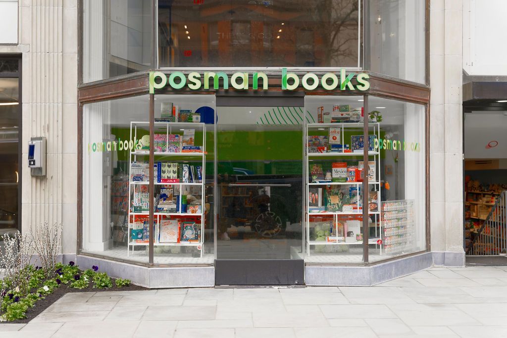 Storefront of Posman Books with large green sign and window displays on a city sidewalk