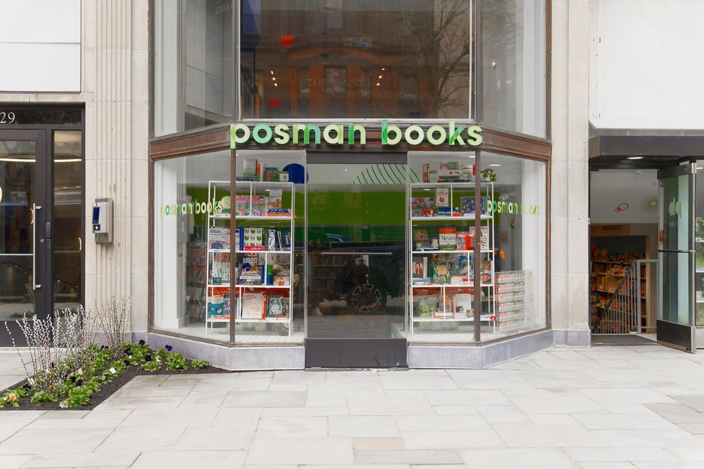 Storefront of Posman Books with glass entrance and display windows on a city sidewalk
