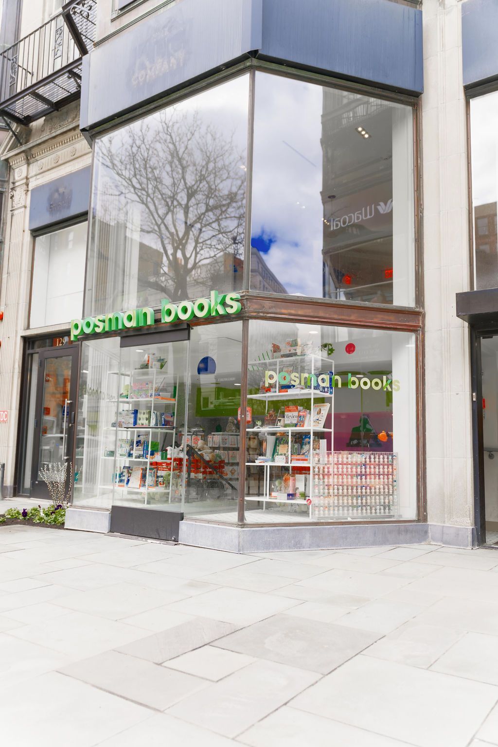 Bookstore storefront with glass windows and green signage on a city street