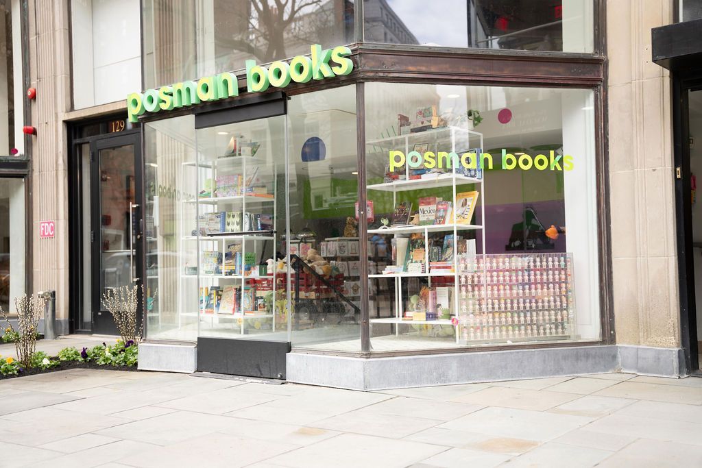 Posman Books storefront with large glass windows and green signage on a city sidewalk