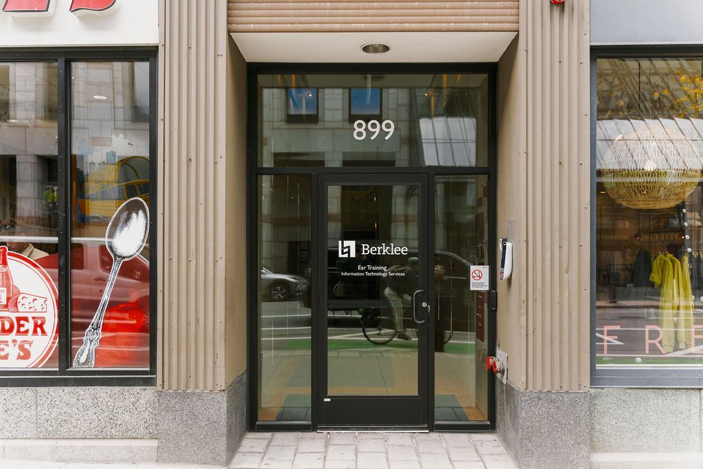 Storefront entrance with glass double doors, street number 899 above, and large display windows.