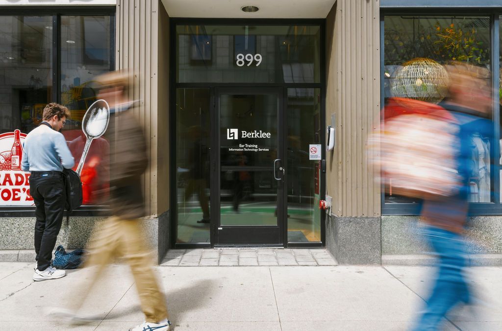 People walking past a glass storefront entrance marked 899
