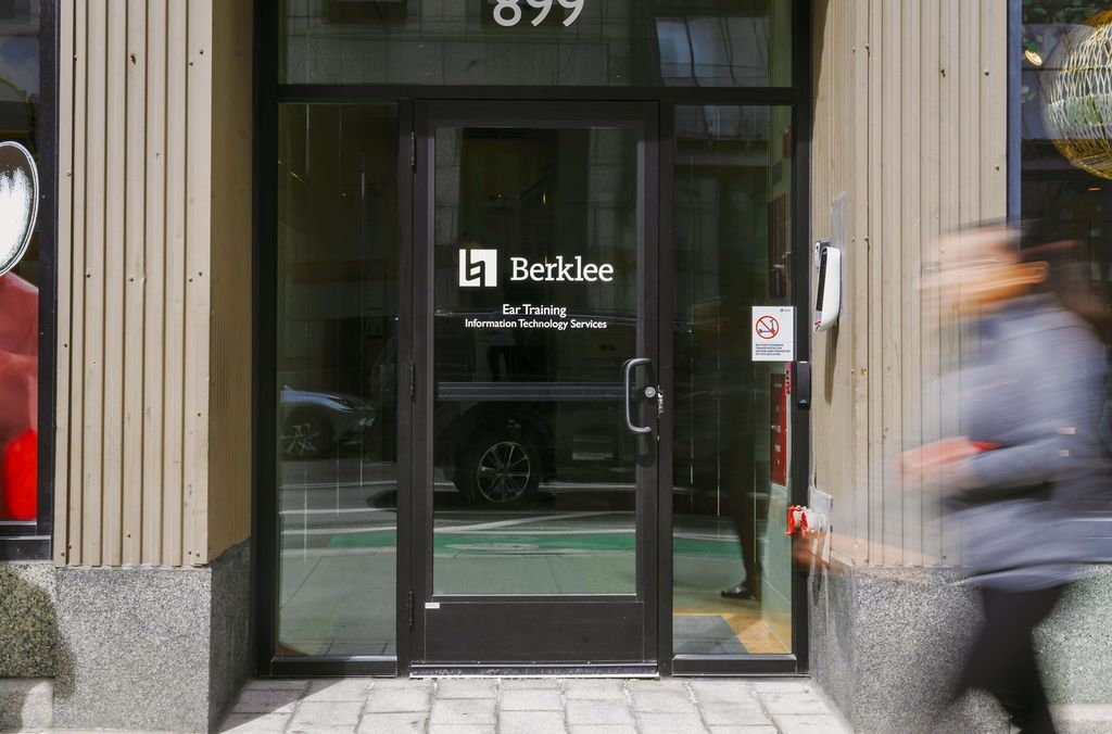 Storefront entrance with glass door and a blurred pedestrian passing by