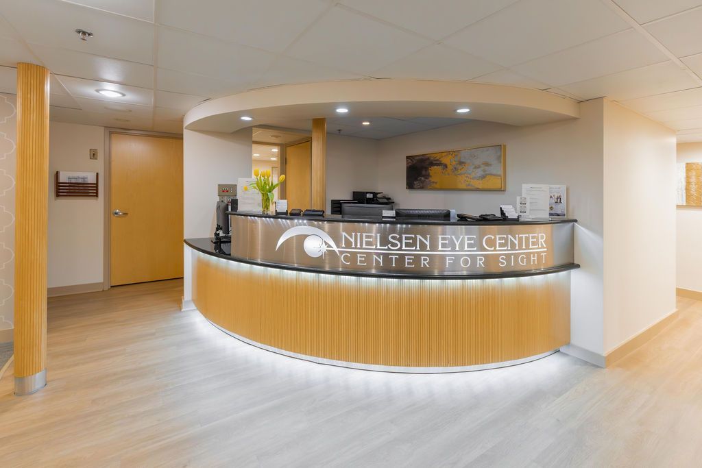 Bright hotel reception desk in a modern lobby with wood paneling and curved counter
