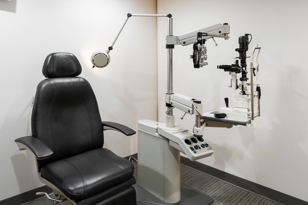 Modern eye exam chair and ophthalmic equipment in a clinic room