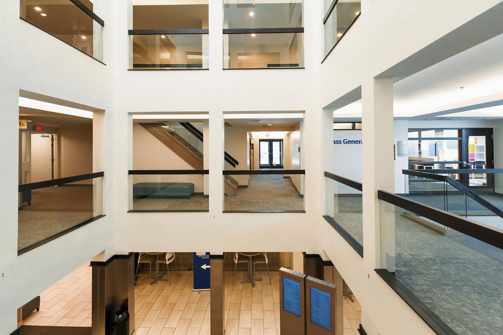 Interior atrium of a modern office or school building with walkways, windows, and staircases across multiple floors
