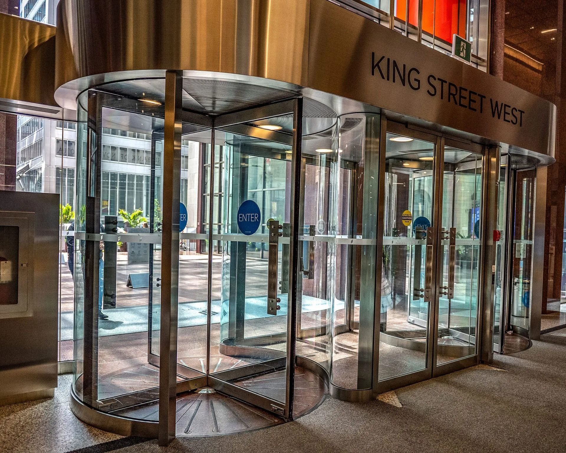 A modern revolving glass door entrance labeled