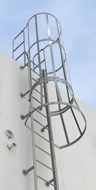 A vertical metal ladder attached to a white wall, featuring a cylindrical safety cage enclosure for climbing protection.