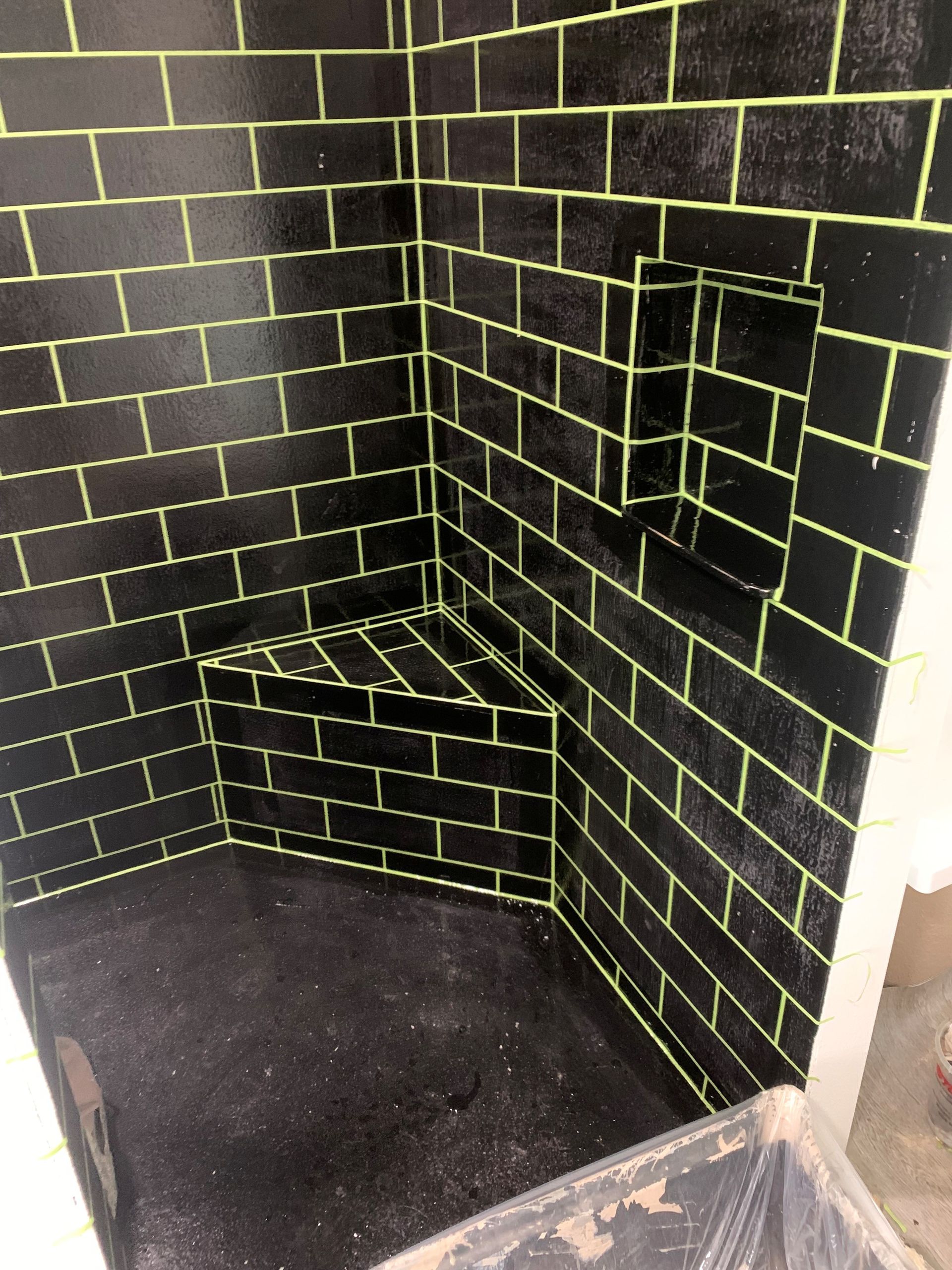 Black room corner with neon yellow grid lines and a small diagonal ledge on the floor