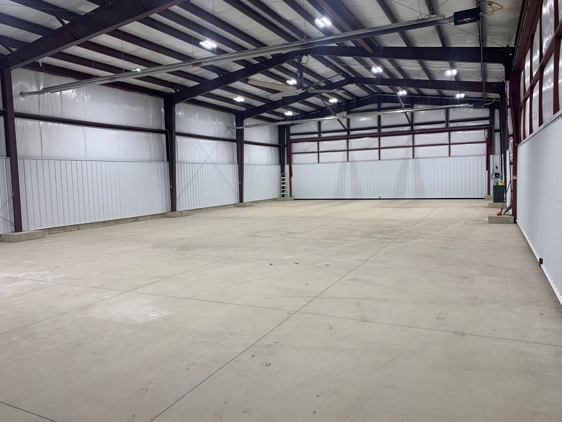 Empty industrial warehouse with a concrete floor and steel beam ceiling
