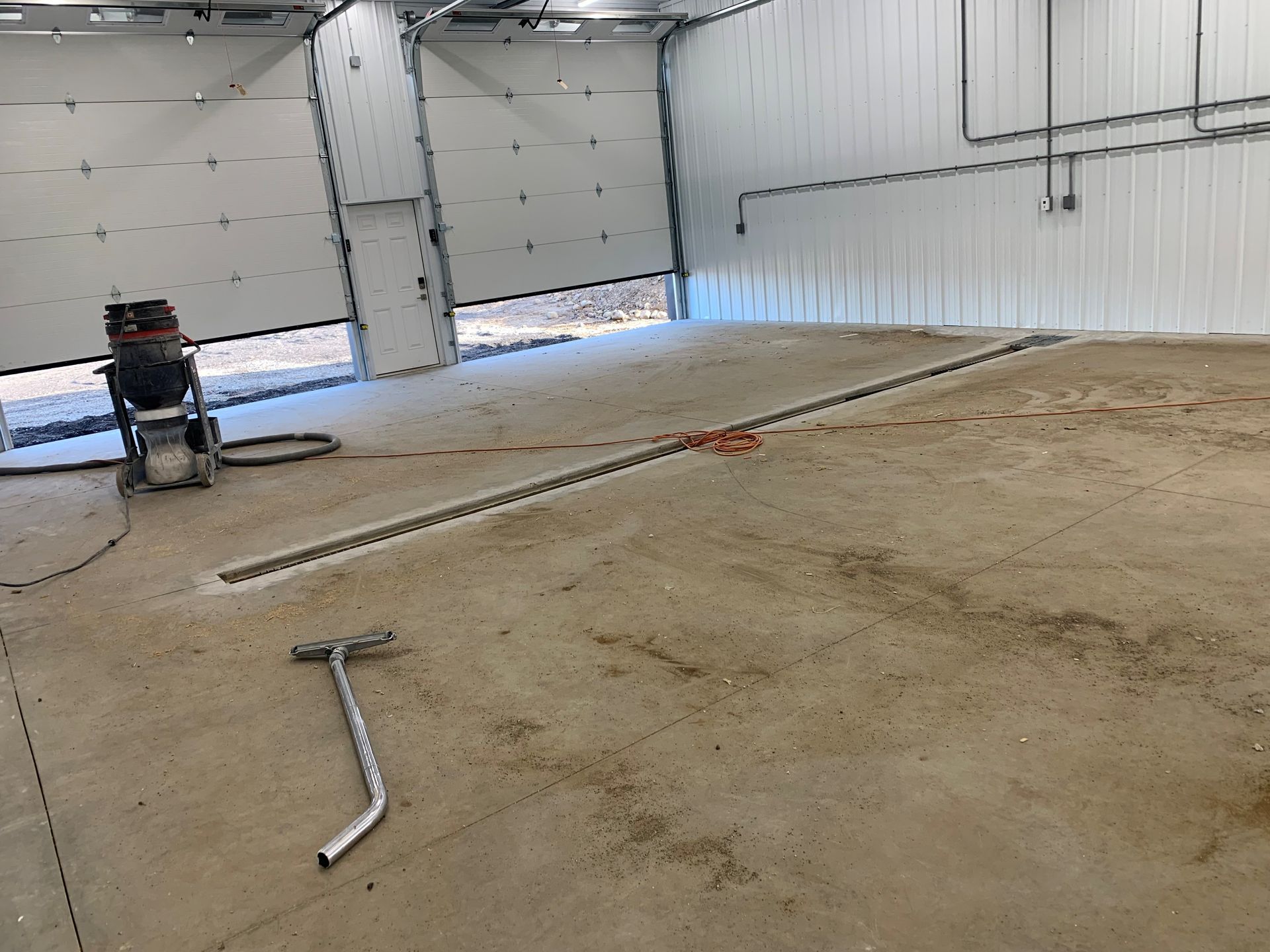 Empty warehouse with a person in a wheelchair near a large open garage door