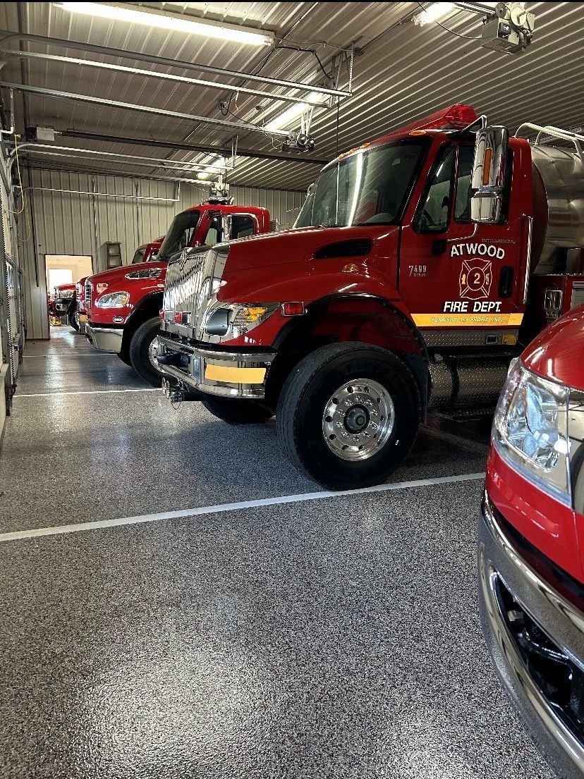 Red fire trucks parked inside a fire station garage.