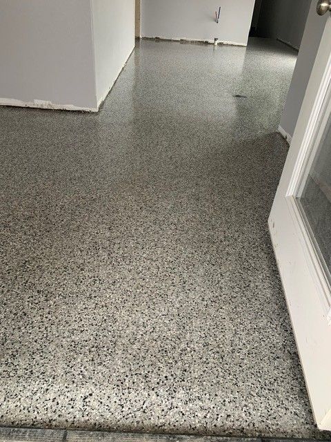 Gray speckled hallway floor and white walls at a corner opening