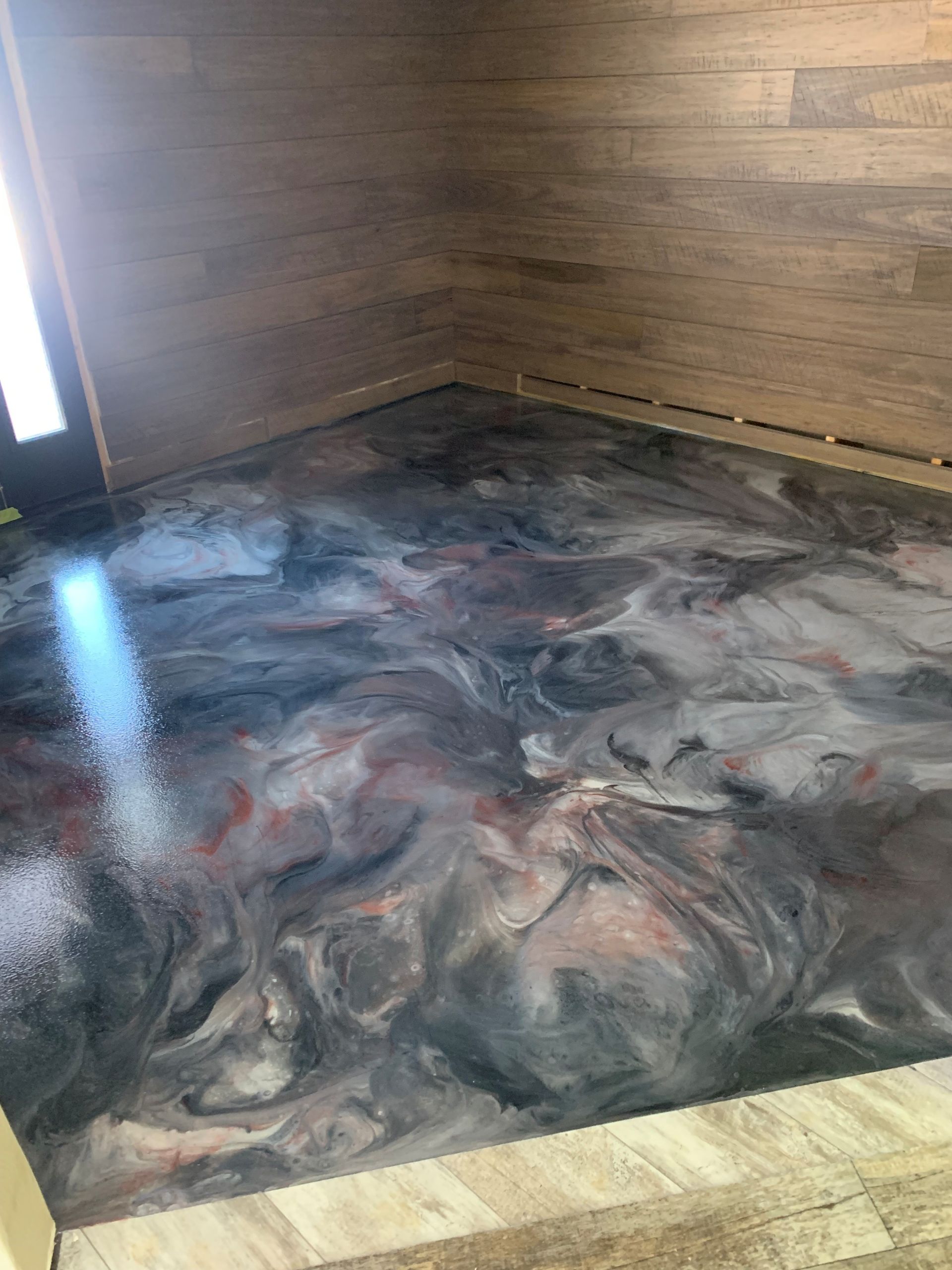Dark marbled floor in a wooden room, with a bright window on the left.