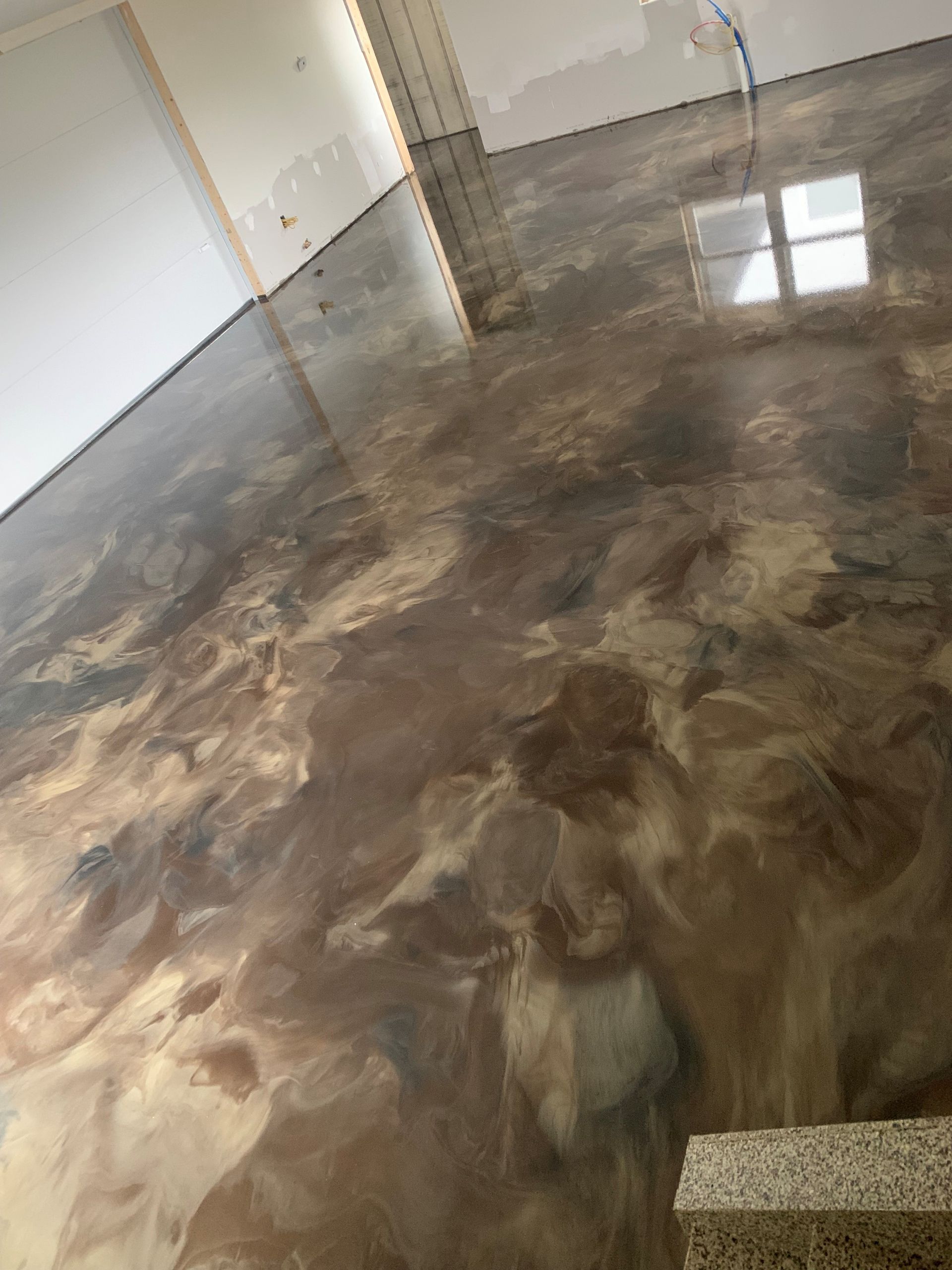Empty room with polished concrete floor and sunlight reflections on the floor