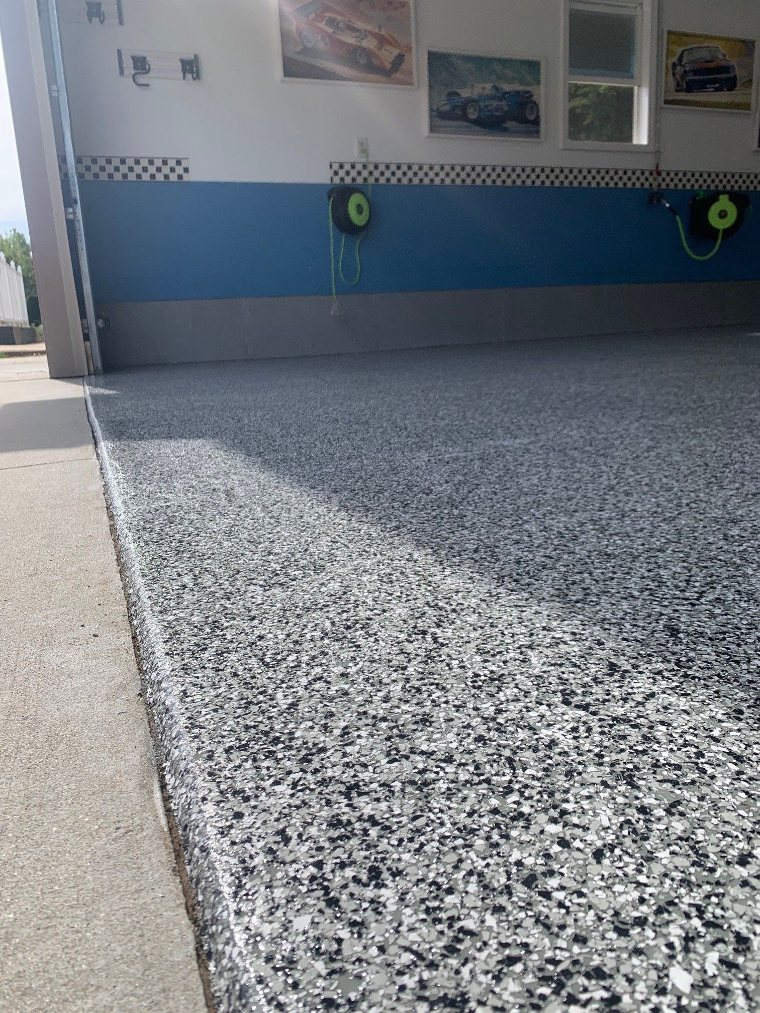 Speckled epoxy floor in front of a blue wall with display photos and life rings.