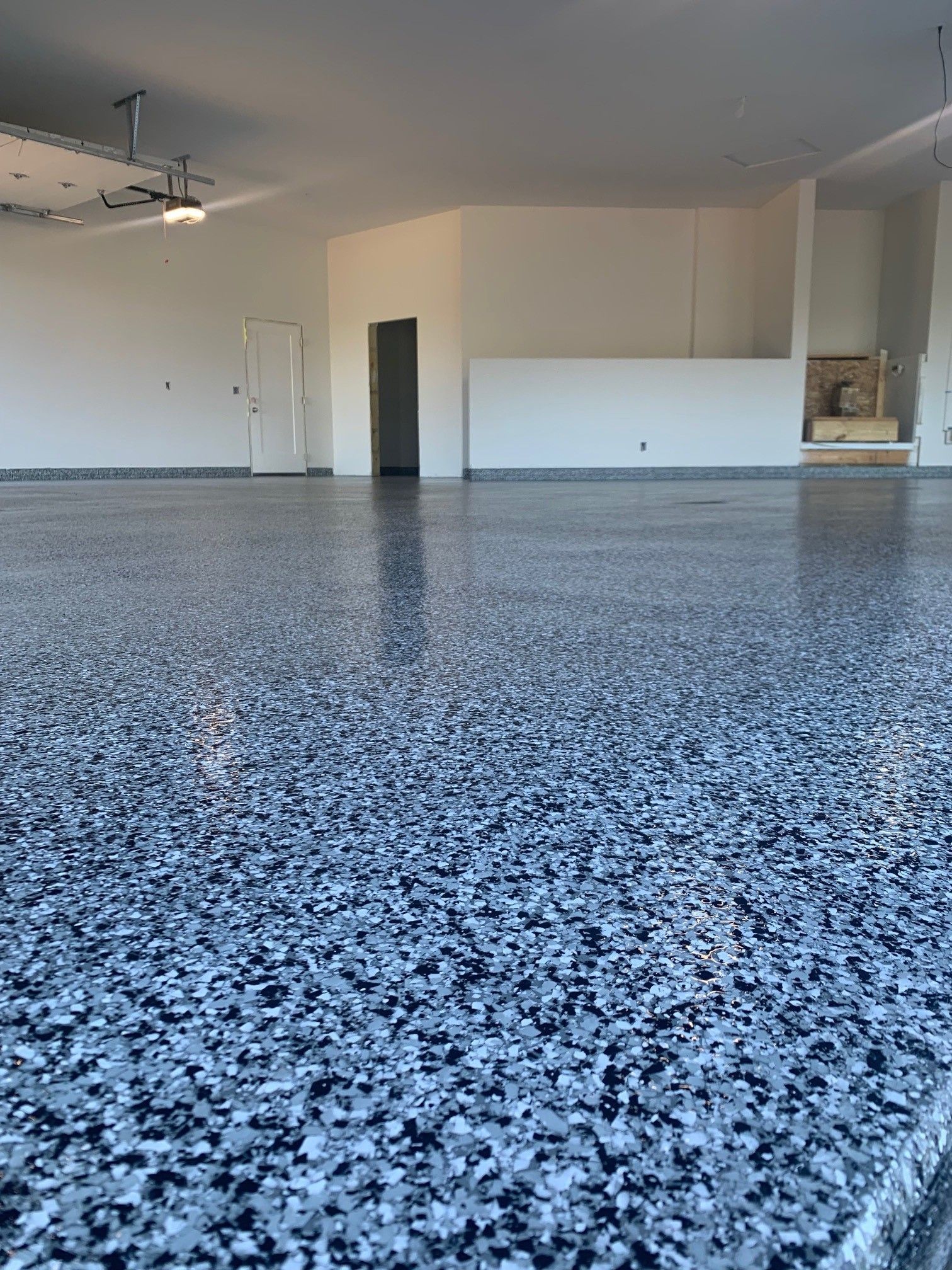 Empty garage with speckled epoxy floor and open interior walls