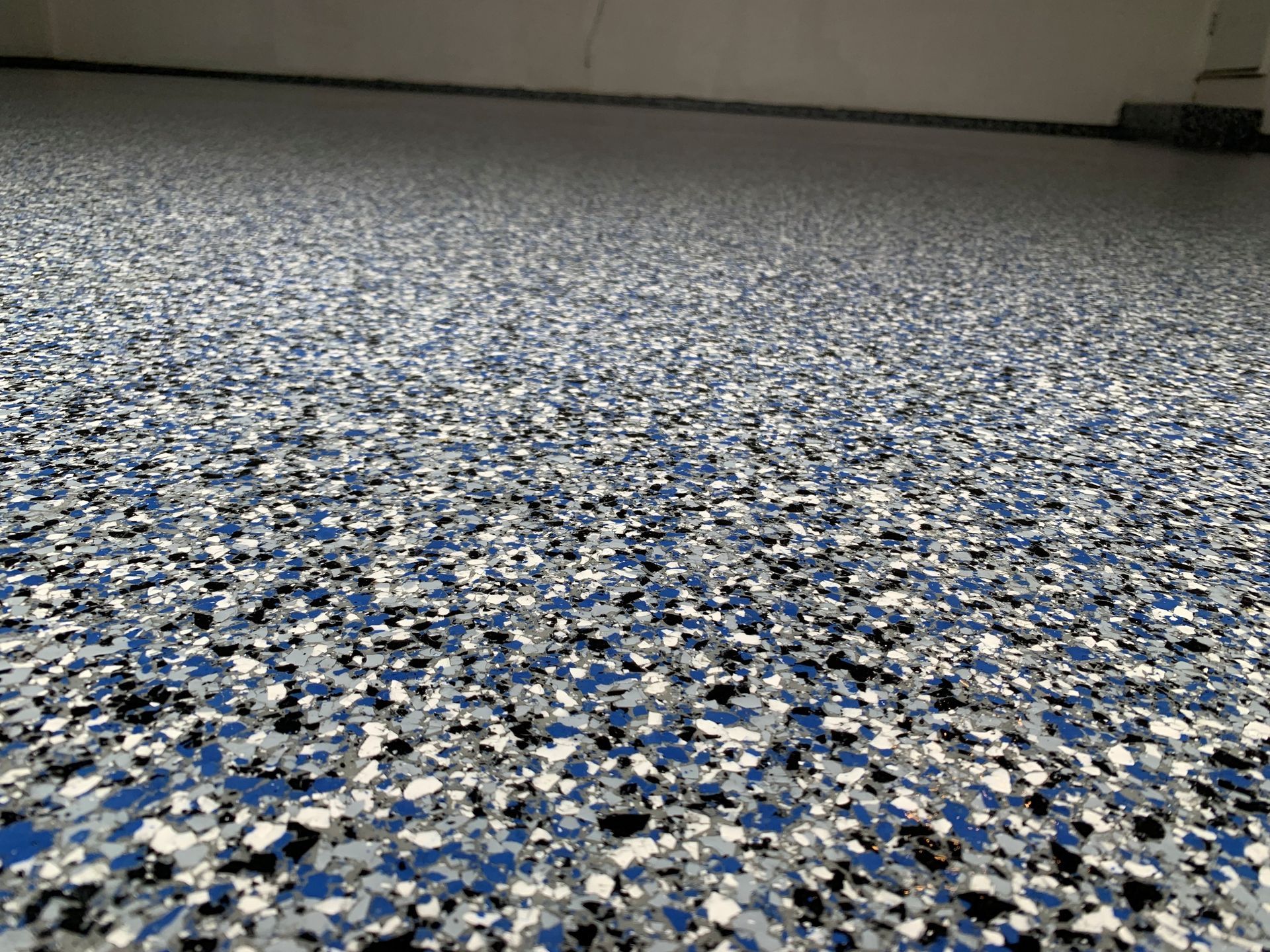 Speckled blue, white, and black terrazzo floor in a plain indoor room