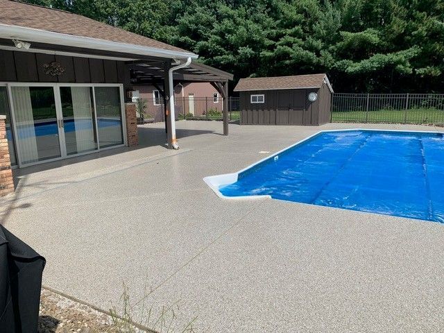 Backyard pool with blue cover beside a house and patio
