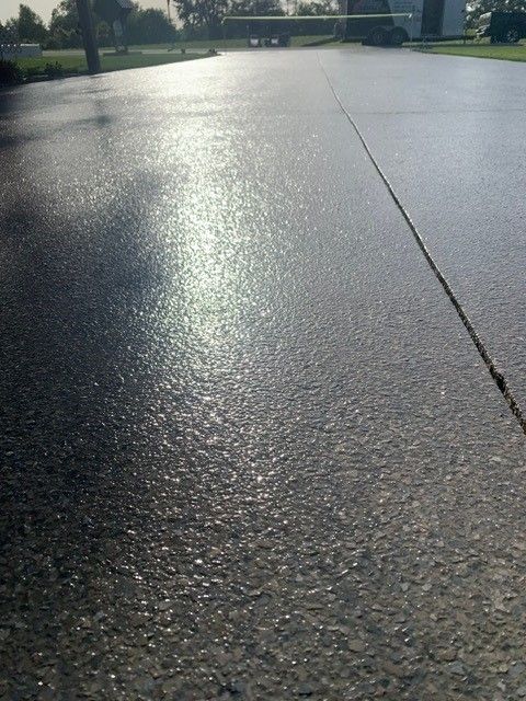 Sunlit wet pavement with bright reflections on a quiet road