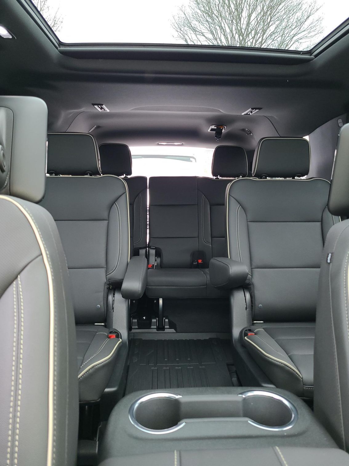 Interior view of a car with black leather seats and a panoramic sunroof.