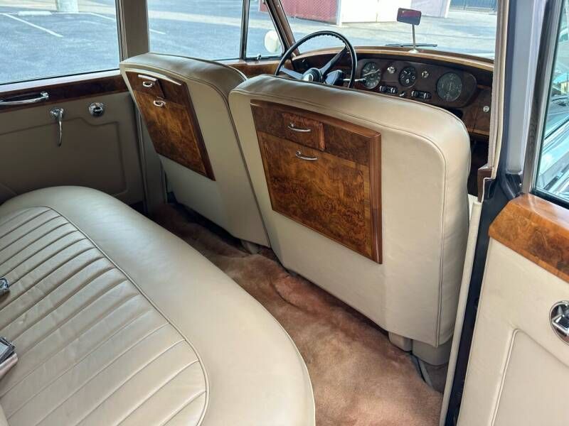 Beige leather interior of a classic car with wood trim.