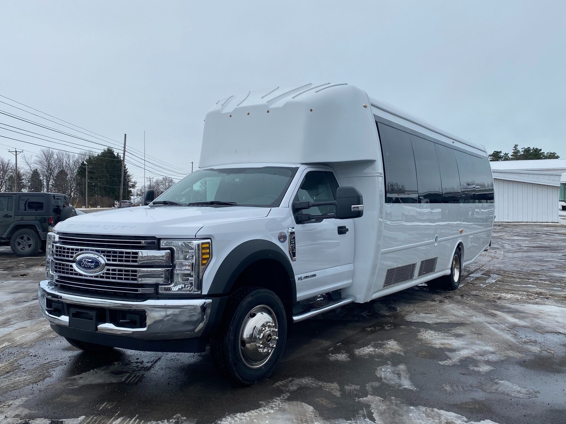 White passenger bus on a snowy surface, parked outside.