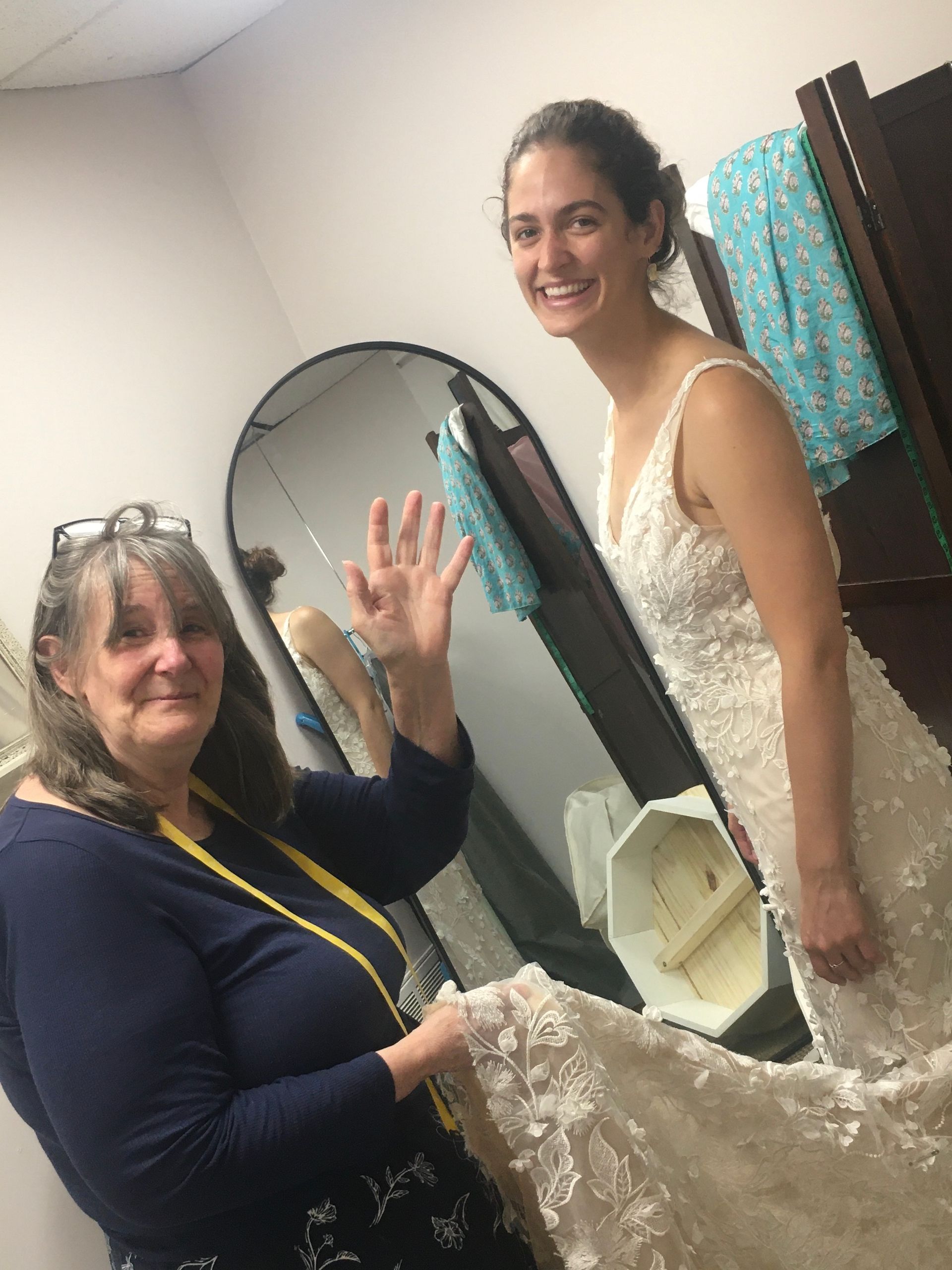 a woman in a wedding dress is standing next to another woman