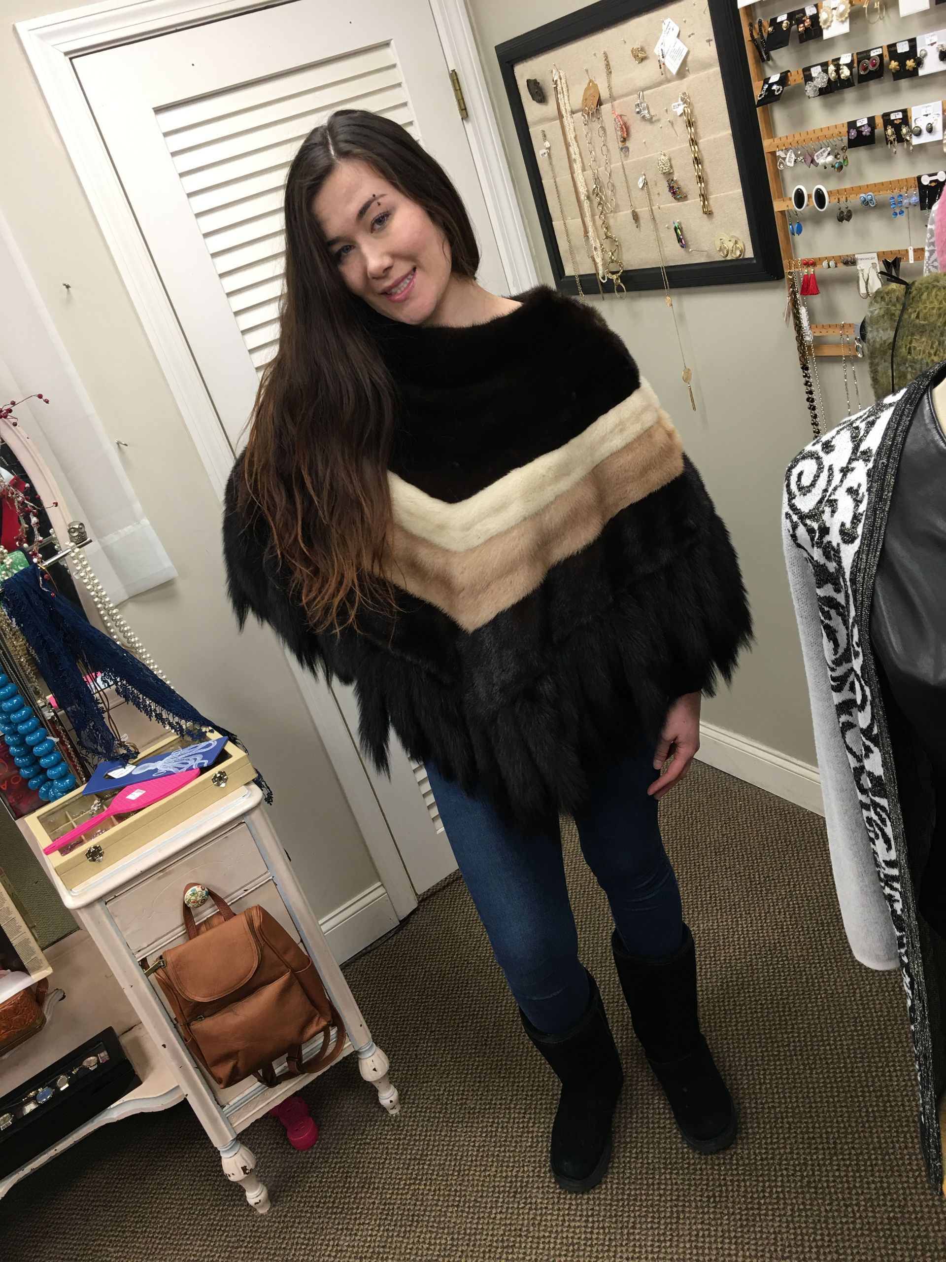 a woman wearing a black poncho is standing in a room
