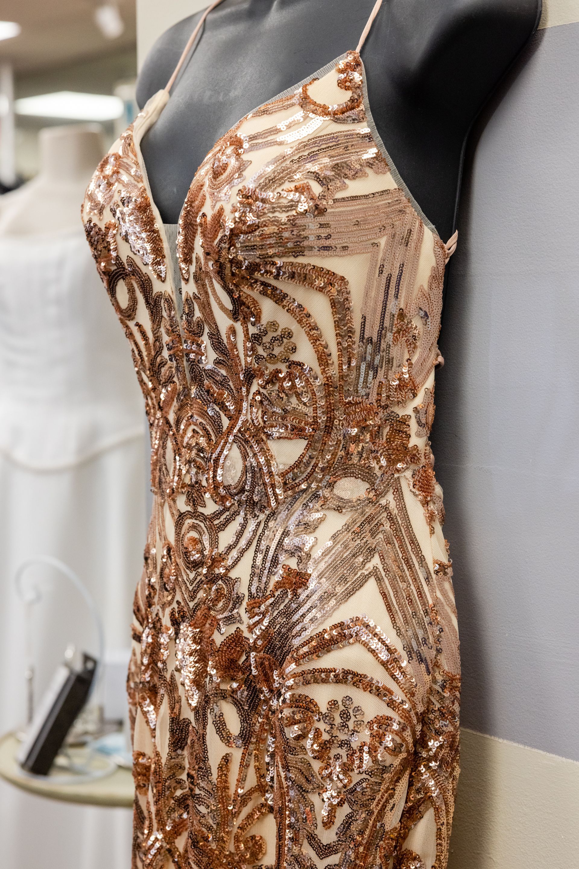 a gold sequined dress is on a mannequin in a store
