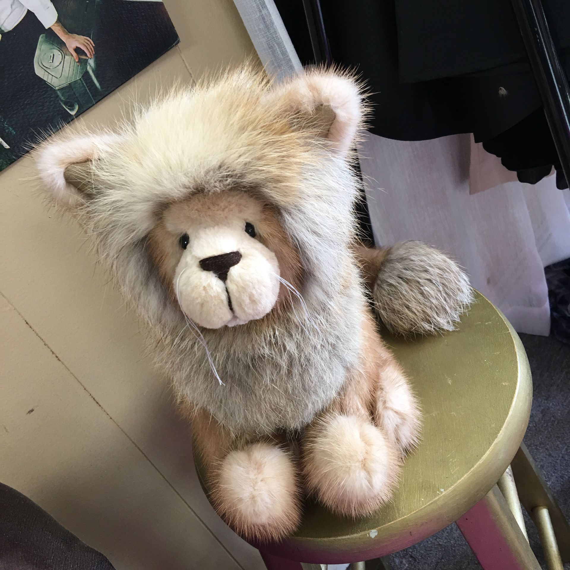 a stuffed lion is sitting on a gold stool