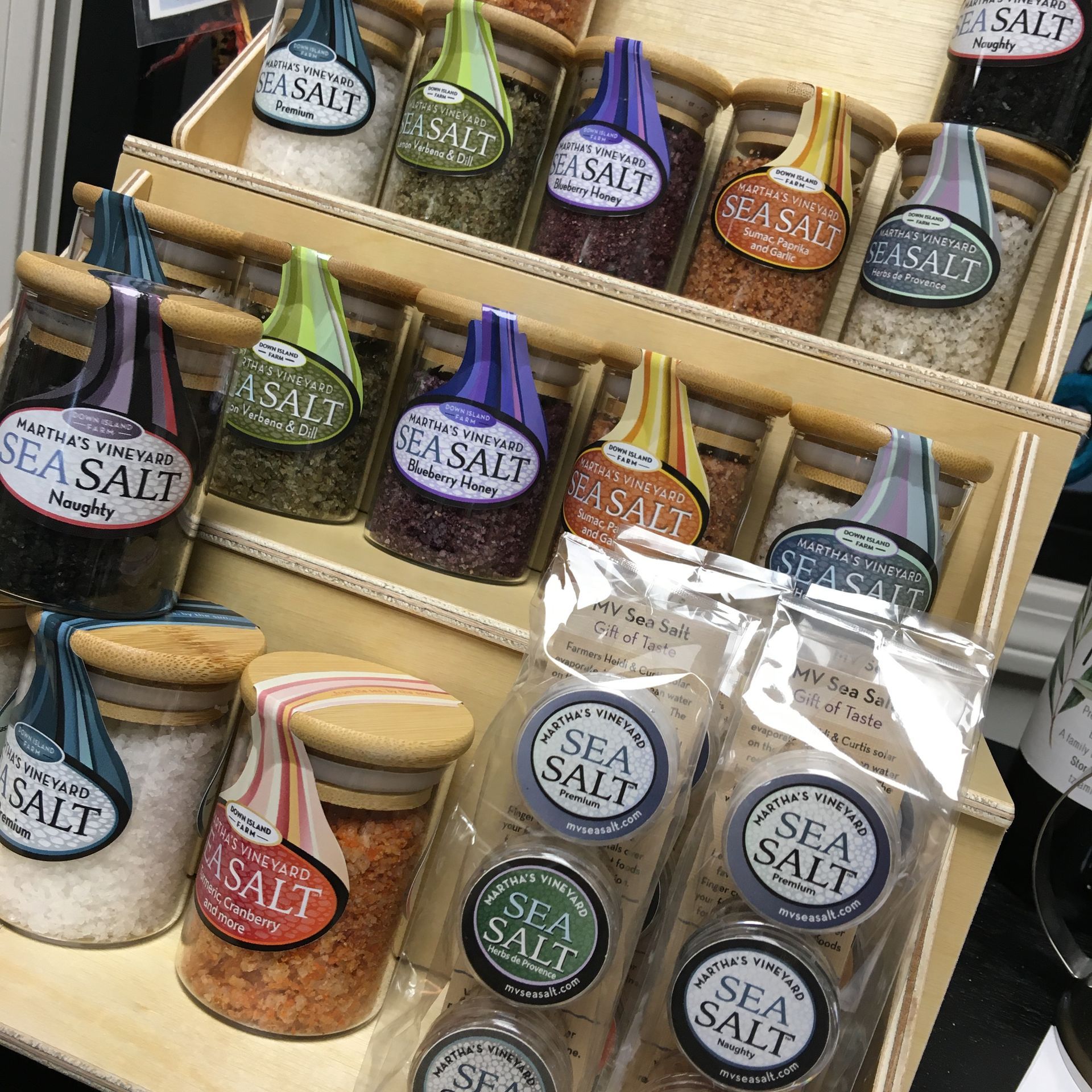 a display of sea salt in jars and bags on a table