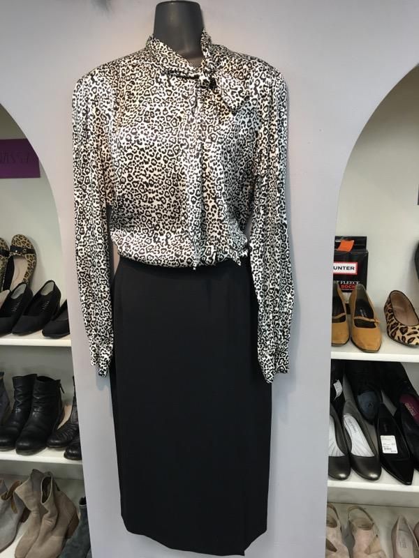 a mannequin is wearing a leopard print shirt and a black skirt