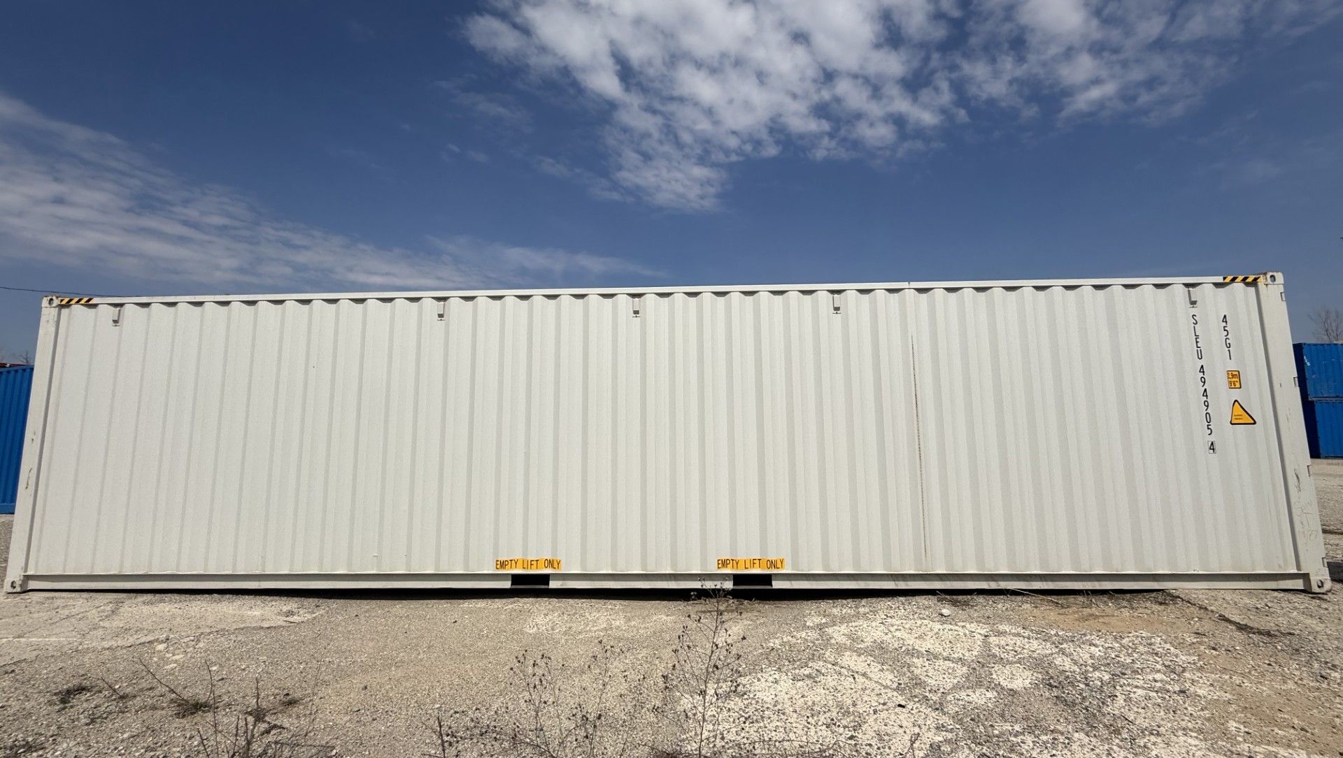 Shipping containers stacked in a port; a truck drives through the containers.
